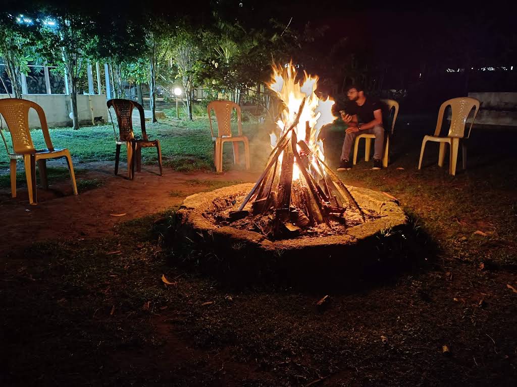 Action shot of tourists enjoying camp fire in Dandeli.